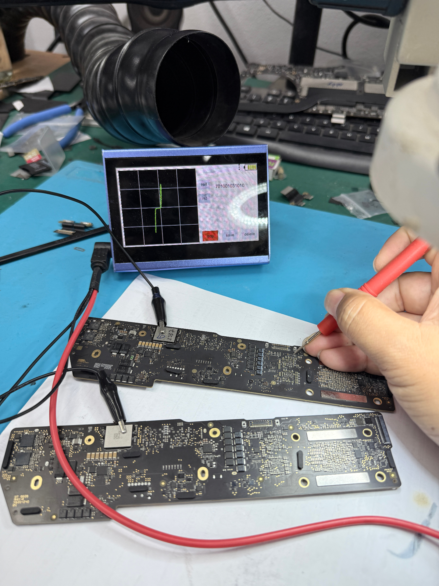 iDevice Shop technician performing iPhone Logic Board micro-soldering repair under a microscope in Vientiane, Laos